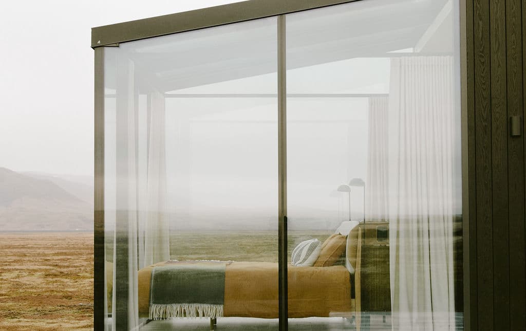 Bedroom with floor-to-ceiling windows showcasing expansive Icelandic landscape at Rafter Seljalandsfoss Lilja in Hvolsvöllur