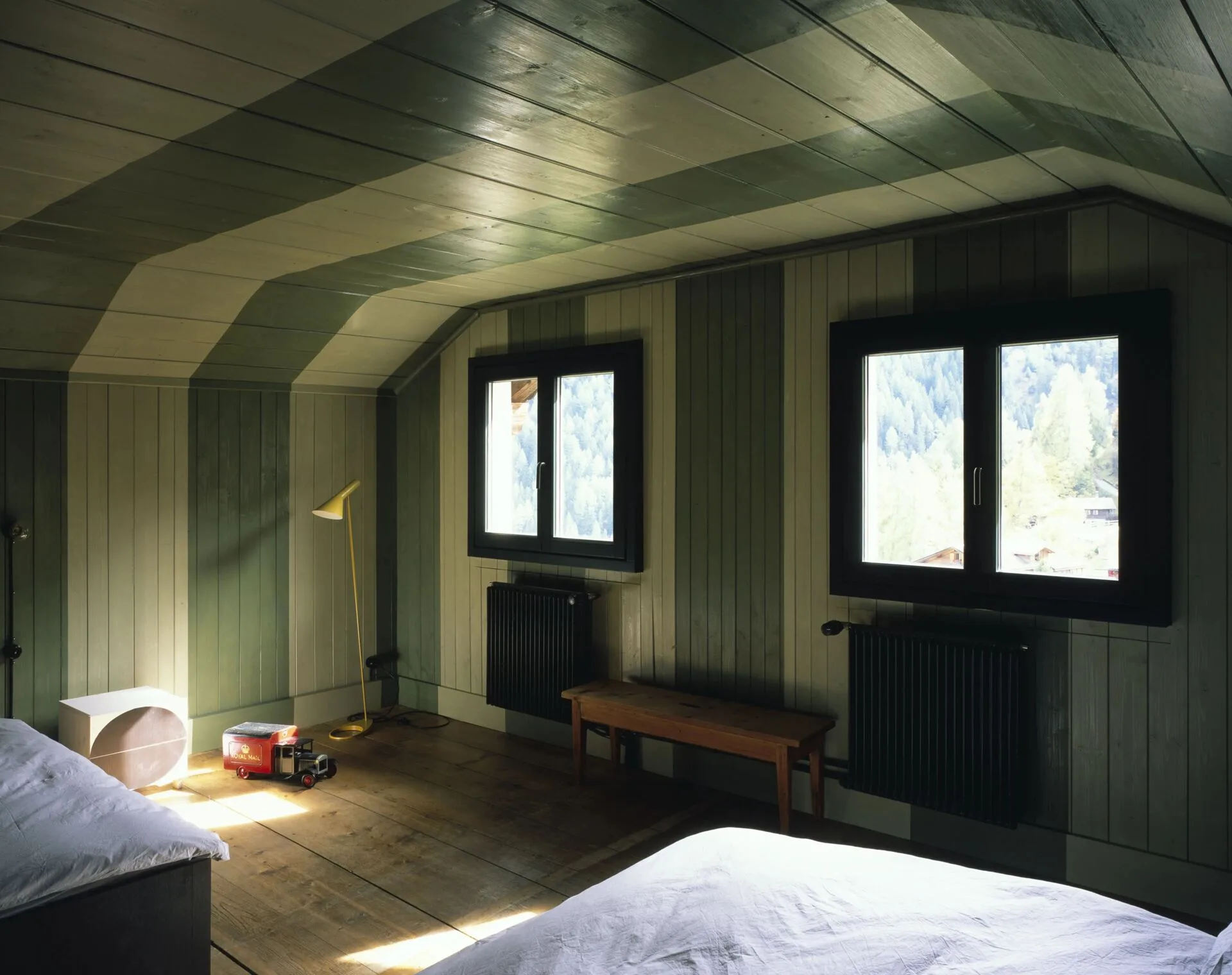 Bedroom with sloped wood-paneled ceiling and mountain views at Rafter Tschiertschen in Tschiertschen, Switzerland