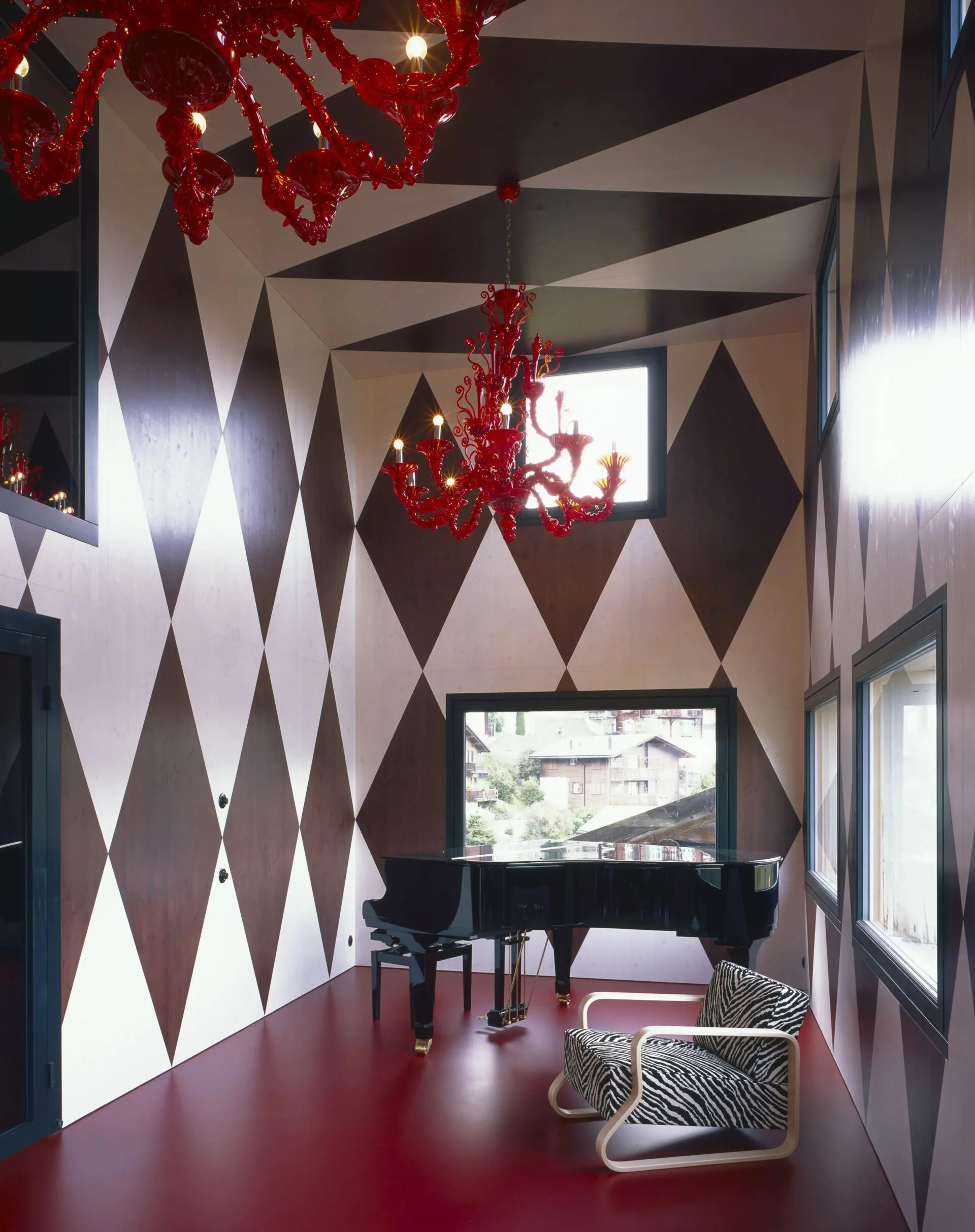 Music room at Rafter Tschiertschen in Tschiertschen, Switzerland with red chandelier and geometric walls