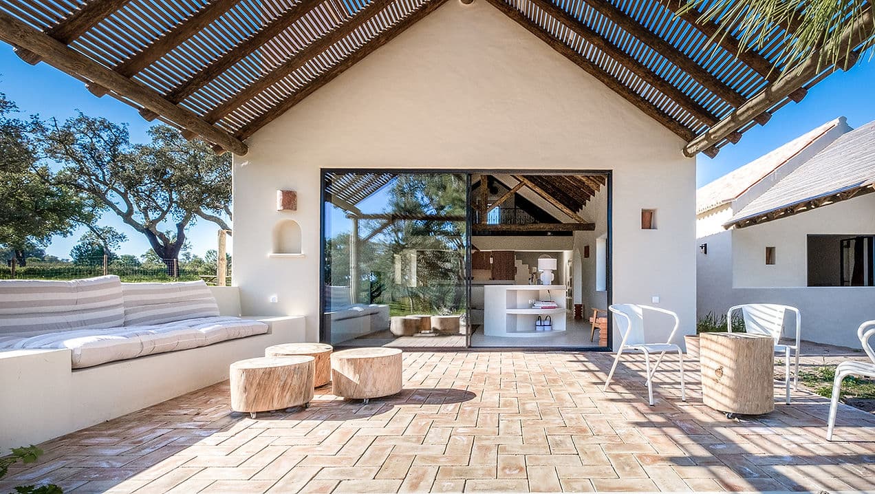 Outdoor terrace with seating and rustic pergola at Rafter Melides Serena in Melides, Portugal