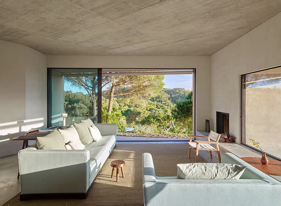 Living room with large windows overlooking forested landscape at Cá na Serra Melides Portugal holiday rental