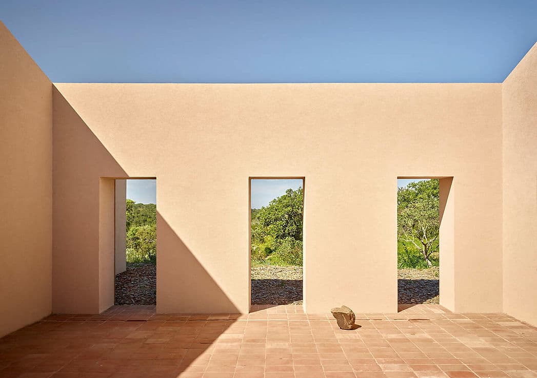 Minimalist terrace with three open doorway views of greenery at Cá na Serra in Melides, Portugal