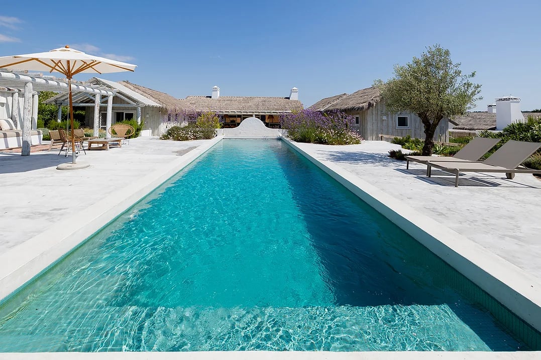 Outdoor swimming pool with sun loungers and umbrellas at Rafter Comporta Celeste in Comporta, Portugal