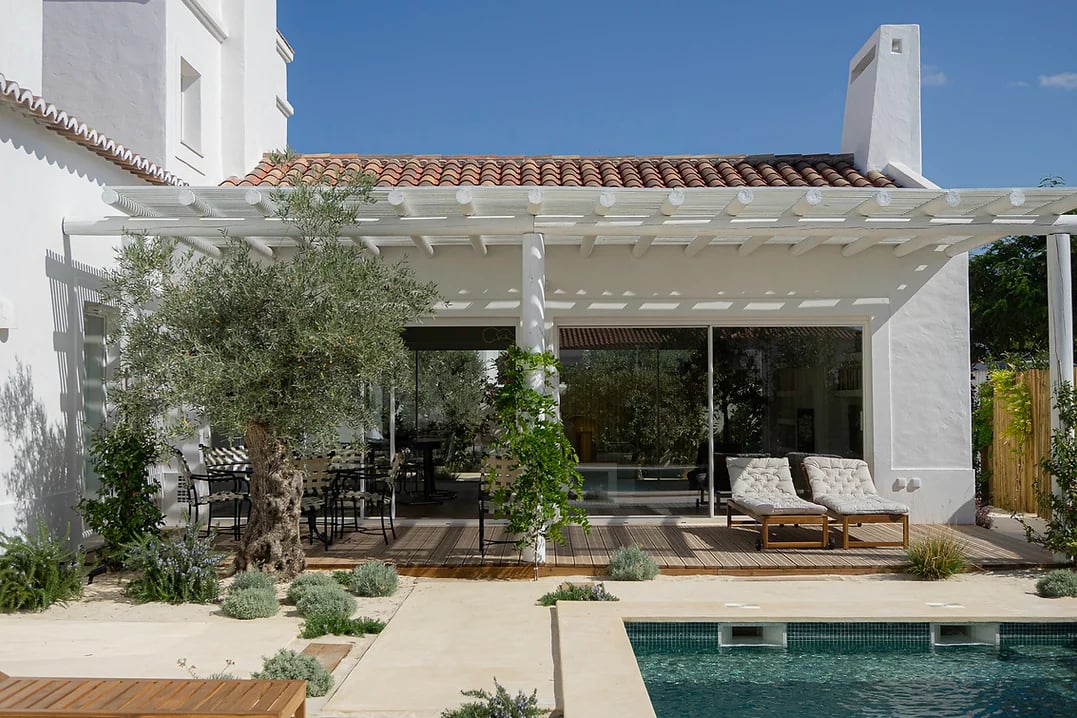 Outdoor patio with seating and lounge chairs overlooking pool at Rafter Melides Oliveiras holiday rental in Melides, Portugal
