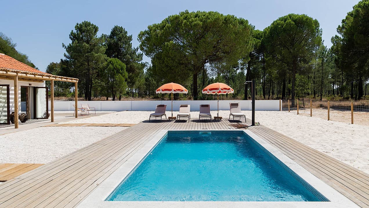 Outdoor swimming pool with sun loungers and umbrellas at Rafter Carvalhal Bicas, Carvalhal, Portugal