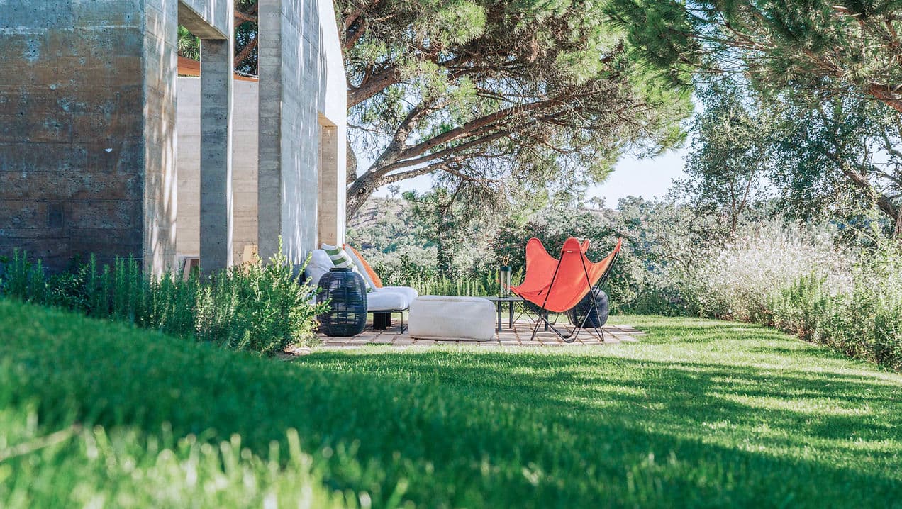 Outdoor seating area with garden view and modern furniture at Rafter Melides Atlantica in Melides, Portugal
