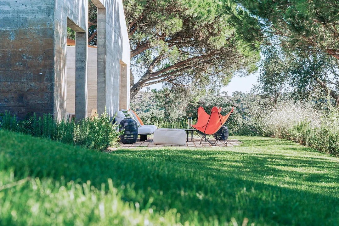 Outdoor seating area with garden view and modern furniture at Rafter Melides Atlantica in Melides, Portugal