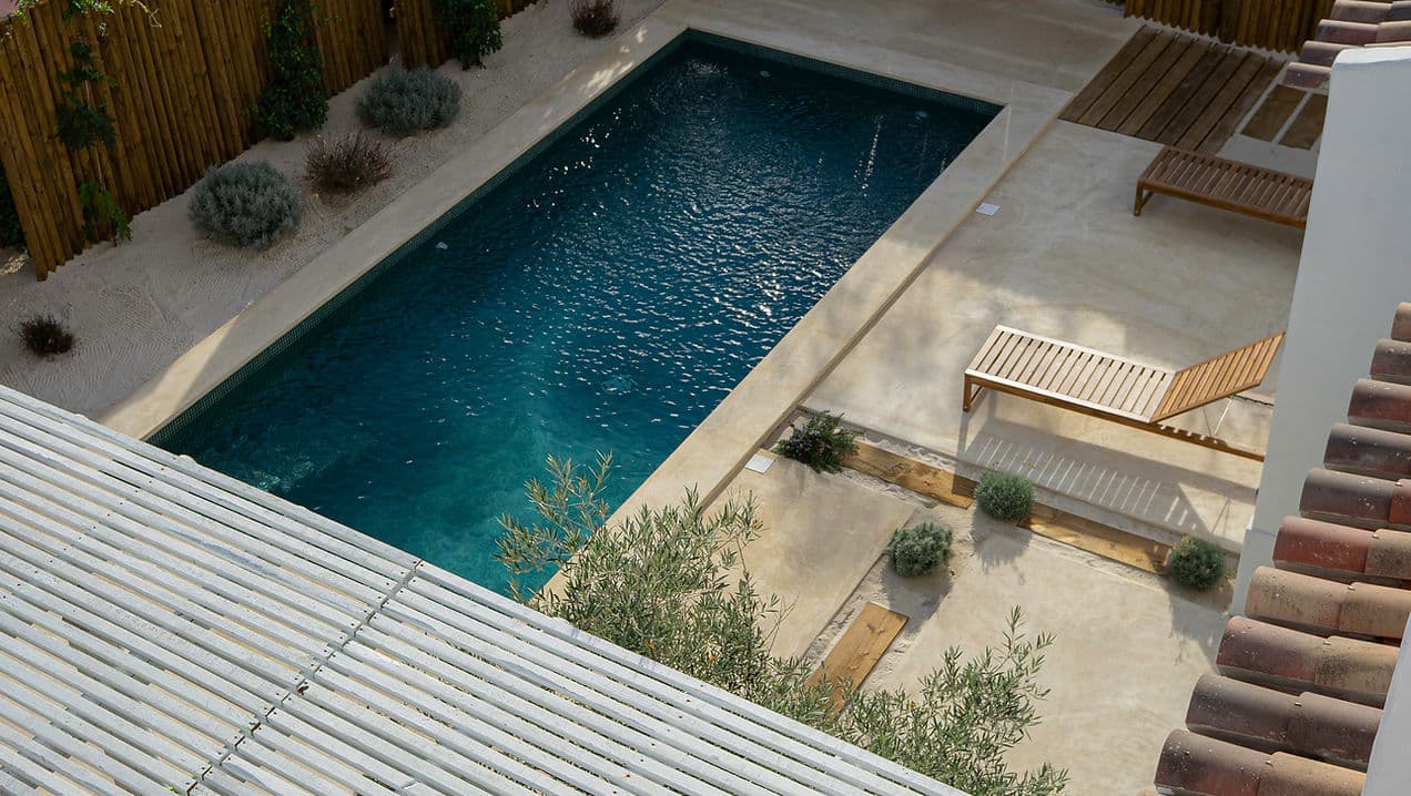 Outdoor swimming pool and lounge chairs at Rafter Melides Oliveiras in Melides, Portugal