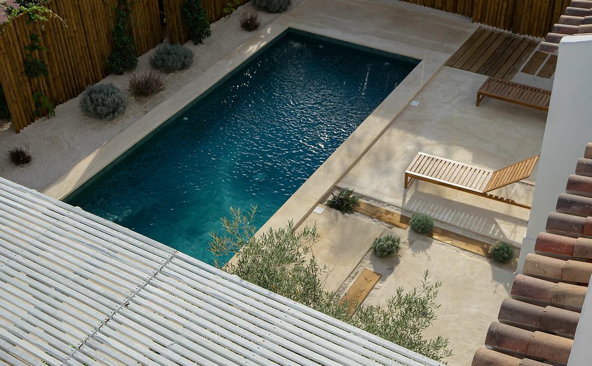 Outdoor swimming pool and lounge chairs at Rafter Melides Oliveiras in Melides, Portugal