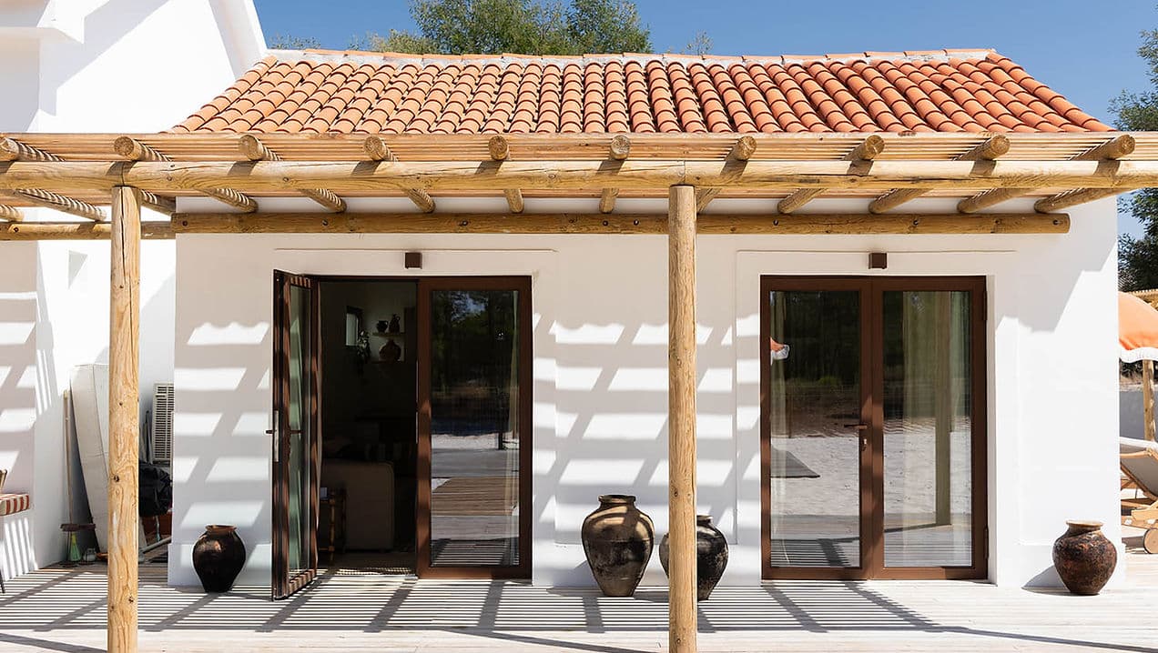Outdoor patio with wooden pergola and terracotta pots at Rafter Carvalhal Bicas in Carvalhal, Portugal