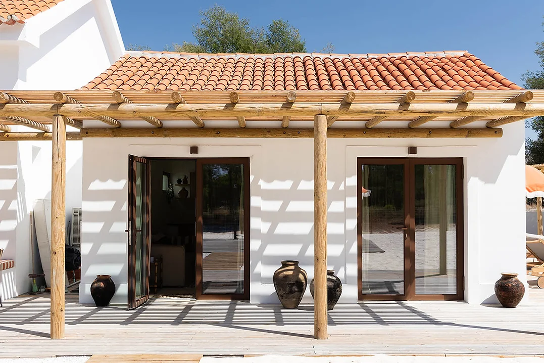 Outdoor patio with wooden pergola and terracotta pots at Rafter Carvalhal Bicas in Carvalhal, Portugal