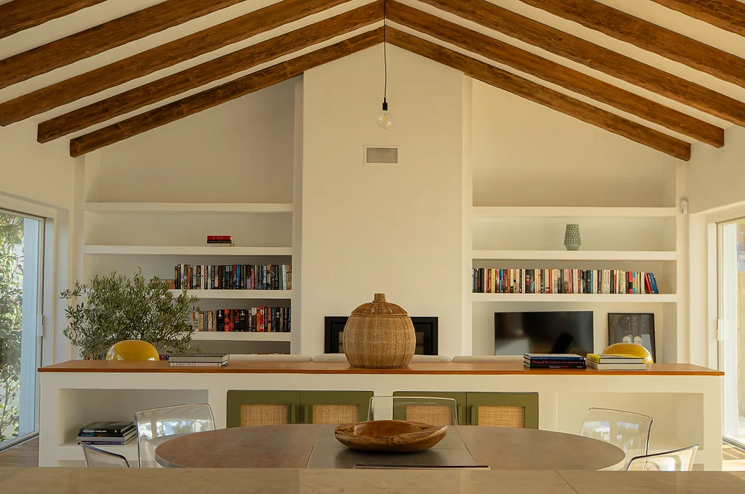Living room with vaulted wood beam ceiling and built-in bookshelf at Rafter Melides Oliveiras in Melides, Portugal
