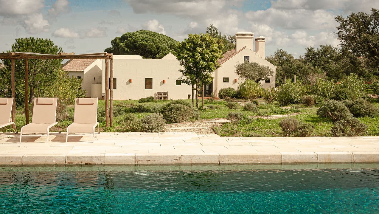 Outdoor pool and sun loungers with garden view at Rafter Melides Serena in Melides, Portugal