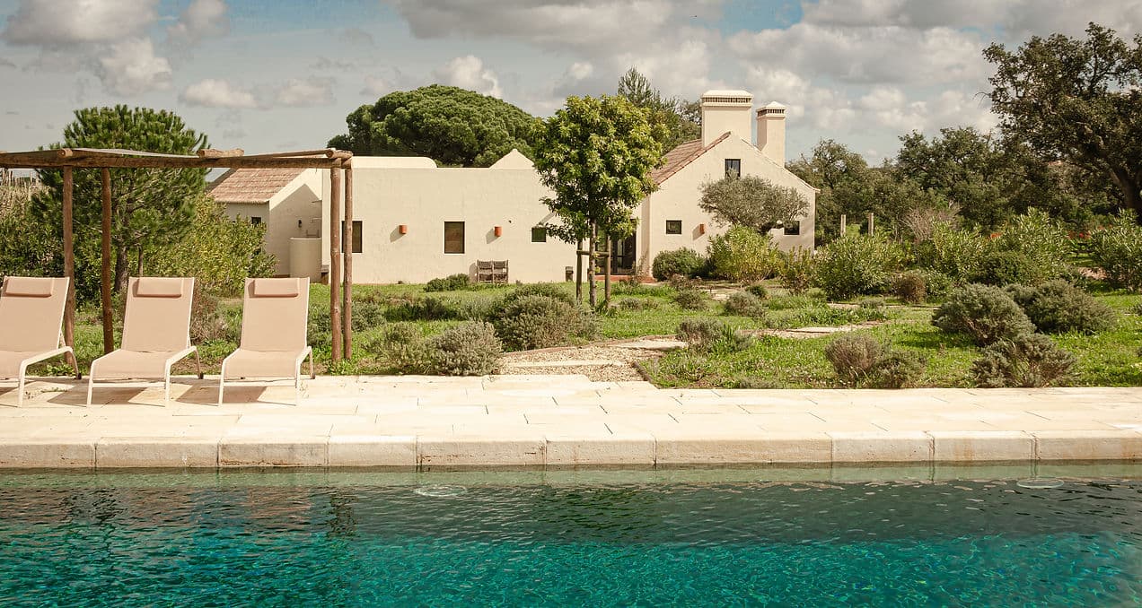 Outdoor pool and sun loungers with garden view at Rafter Melides Serena in Melides, Portugal