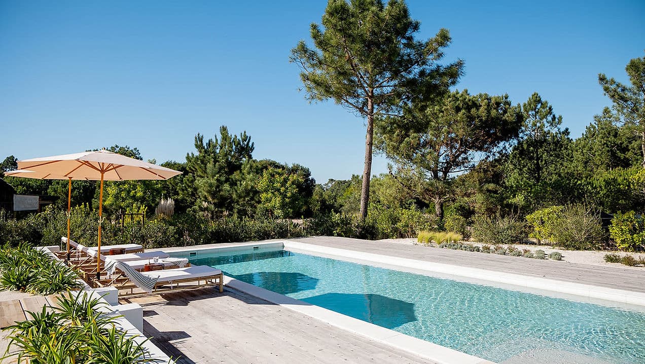 Outdoor swimming pool with lounge chairs and umbrellas at Casa AHA at Casa AHA!, Carvalhal / Comporta