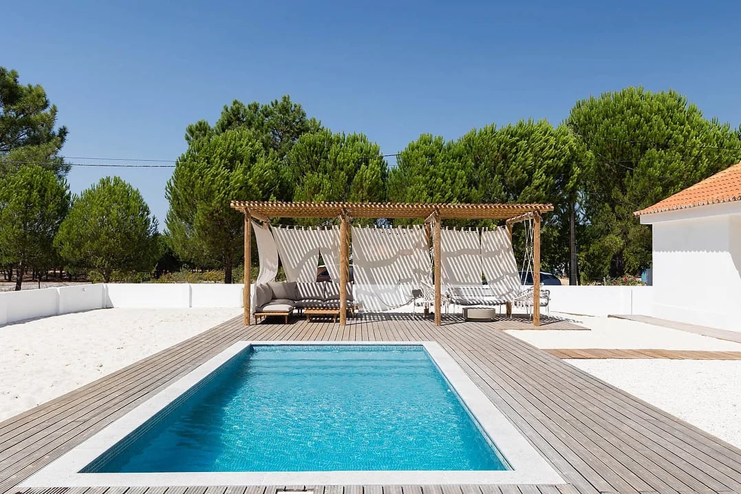 Outdoor pool and shaded seating area with curtains at Rafter Carvalhal Bicas in Carvalhal, Portugal