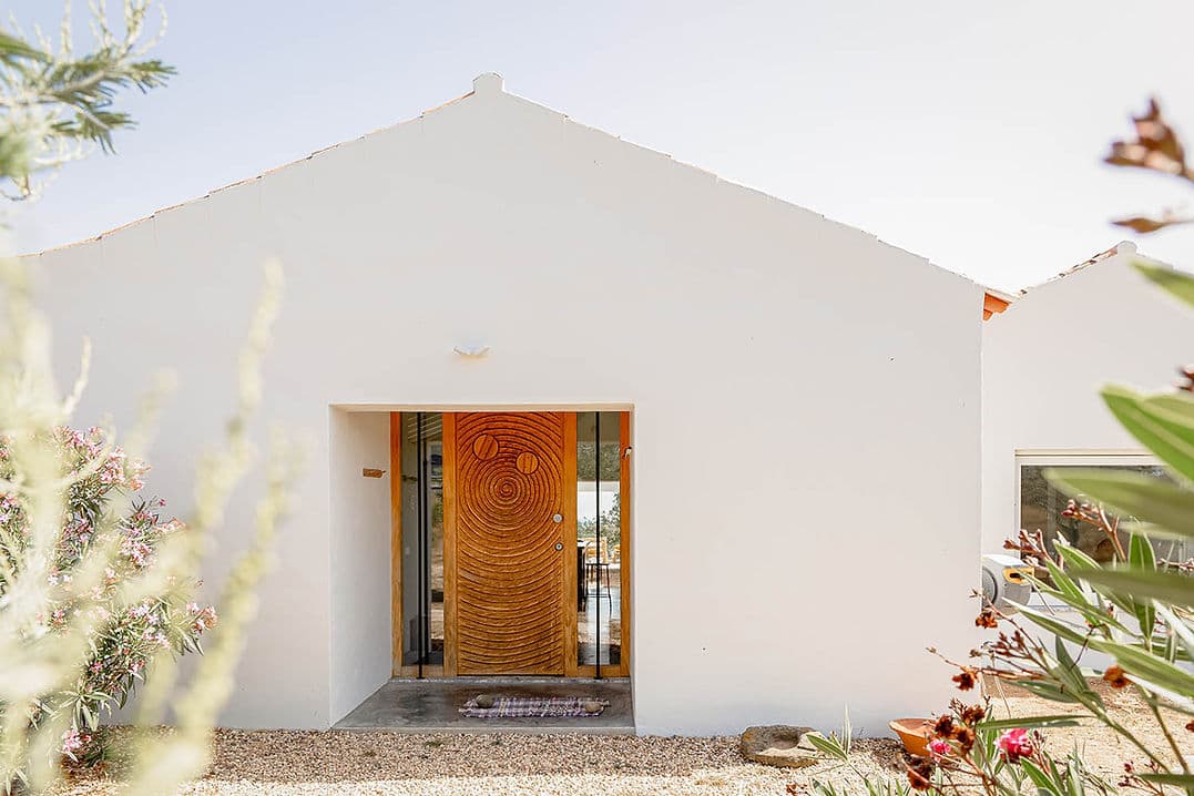 White facade with artistic wooden front door at Casa Acima, Santiago do Cacém, Portugal vacation rental