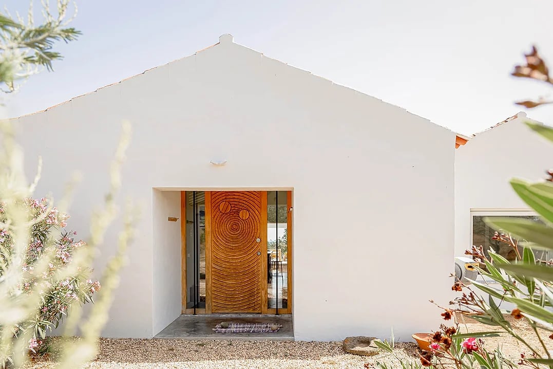 White facade with artistic wooden front door at Casa Acima, Santiago do Cacém, Portugal vacation rental