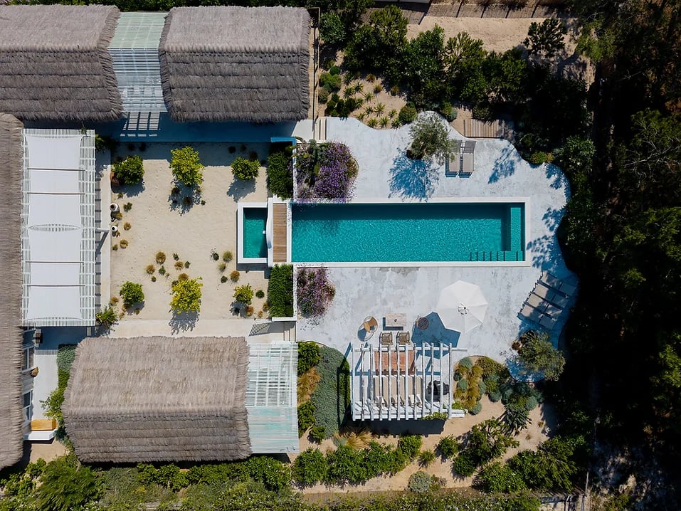 Aerial view of outdoor pool and sun loungers at Rafter Comporta Celeste in Comporta, Portugal