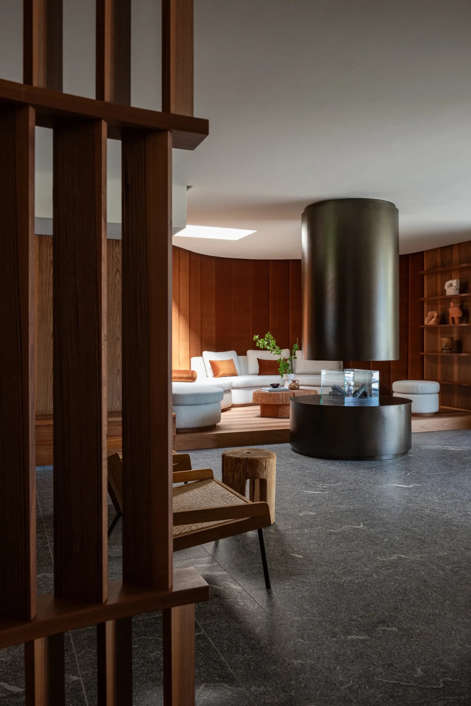 Living room with modern suspended fireplace and curved seating at Rafter Merano Algund in Italy