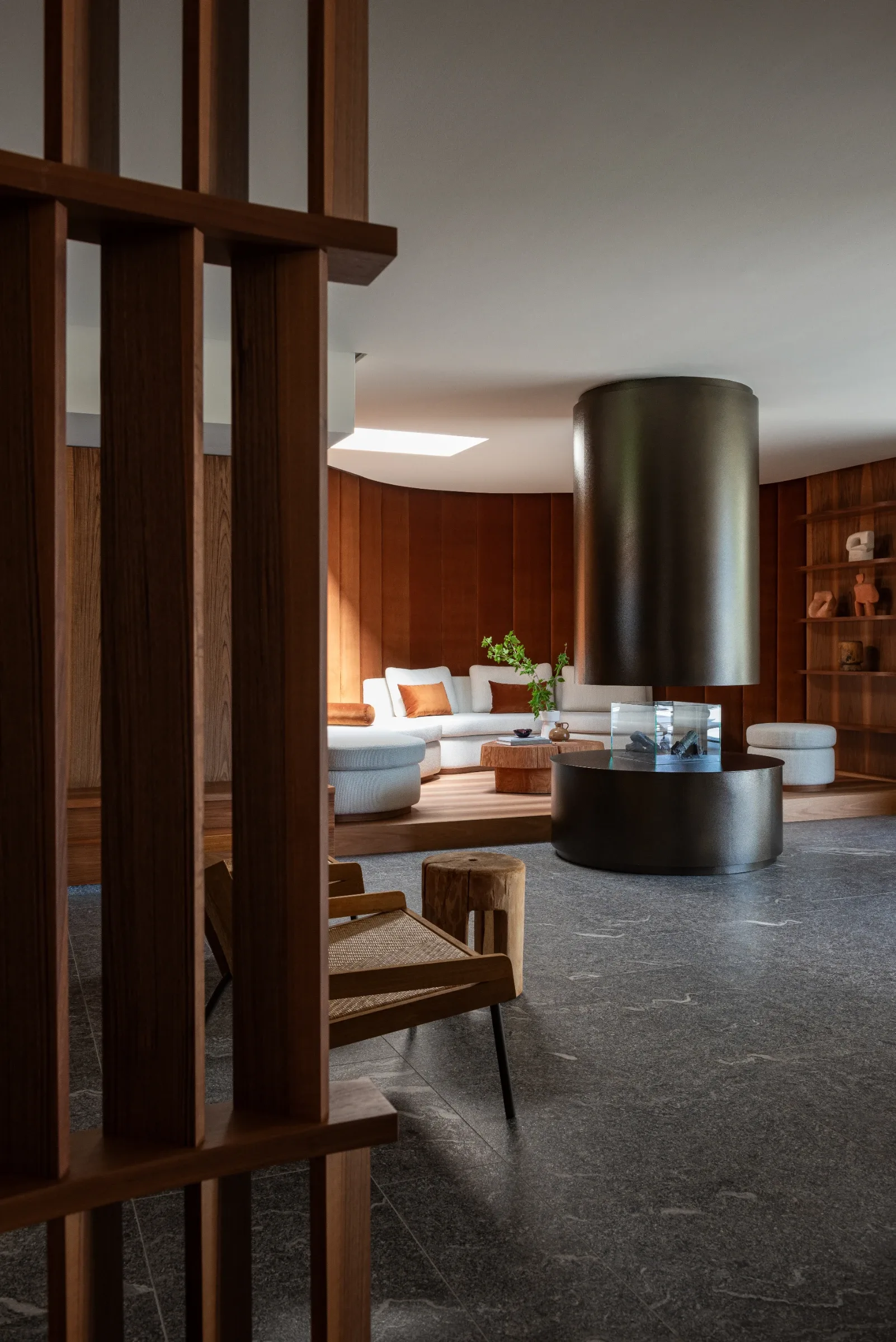 Living room with modern suspended fireplace and curved seating at Rafter Merano Algund in Italy