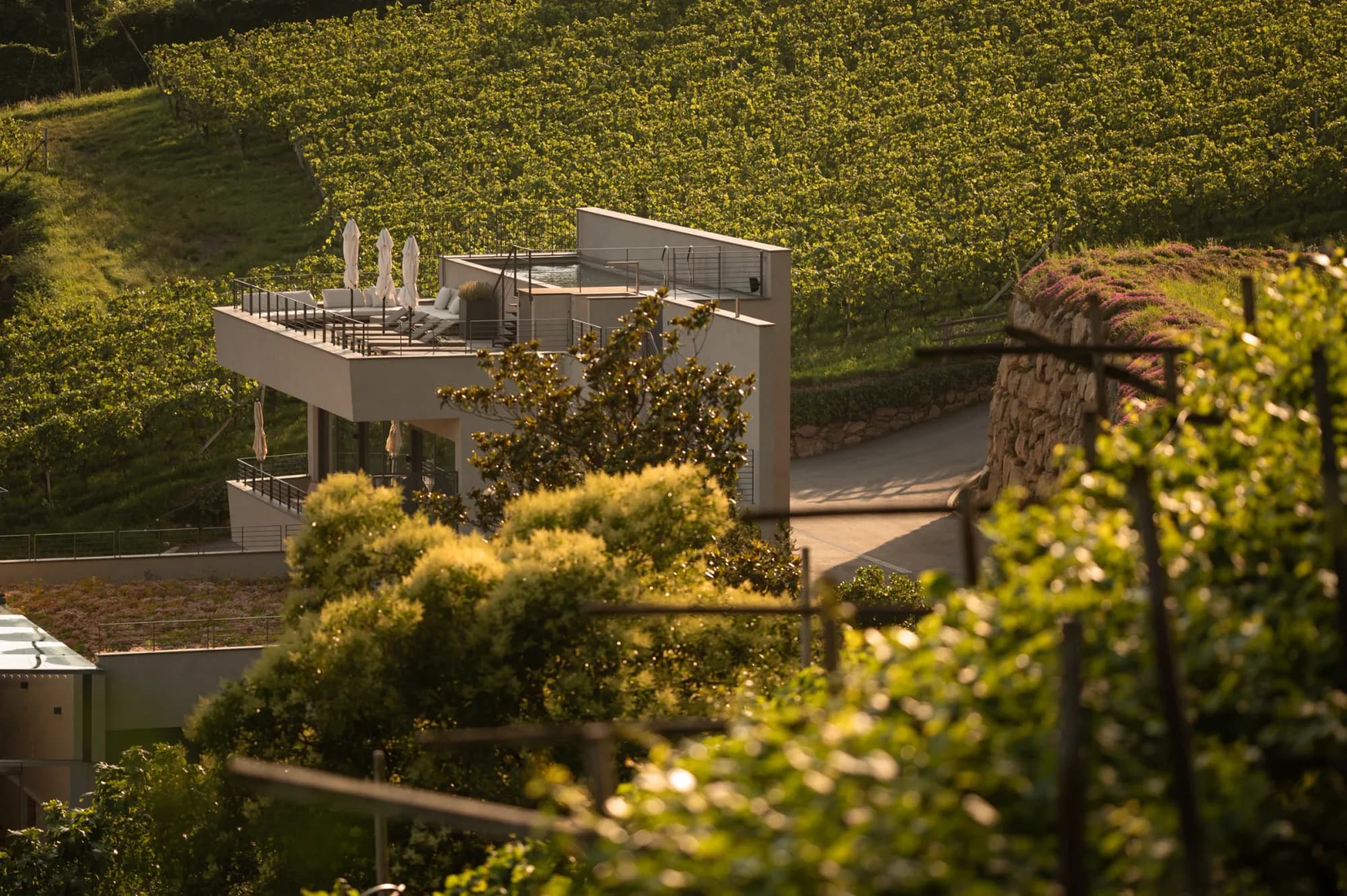 Rafter Merano Algund rooftop terrace with sun loungers and vineyard views in Algund, Italy
