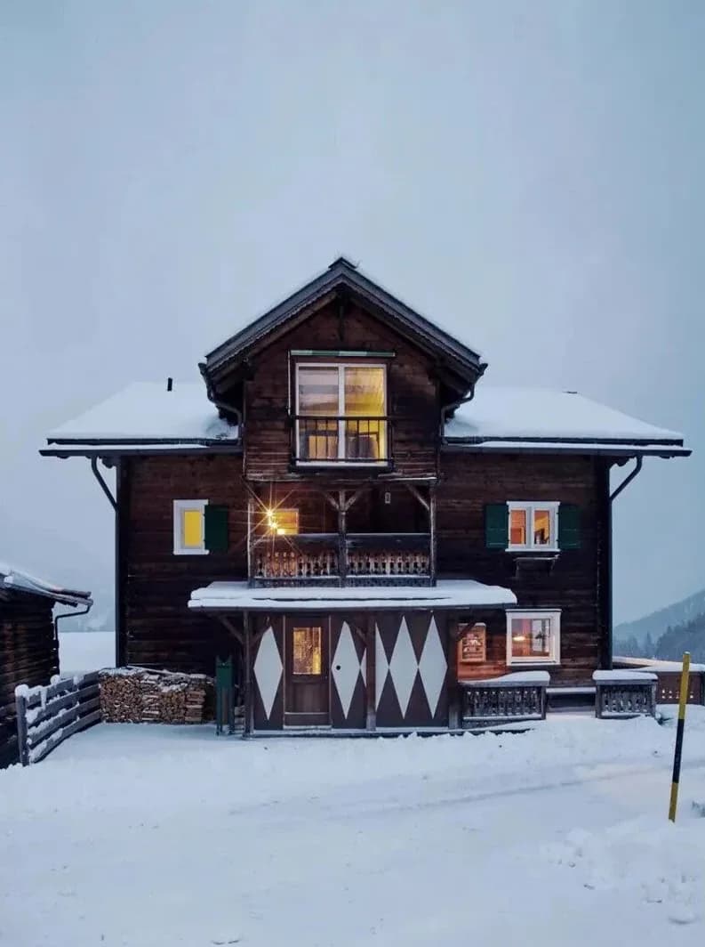 Rustic wooden chalet exterior at Rafter Tschiertschen in snowy Tschiertschen, Switzerland with balcony view