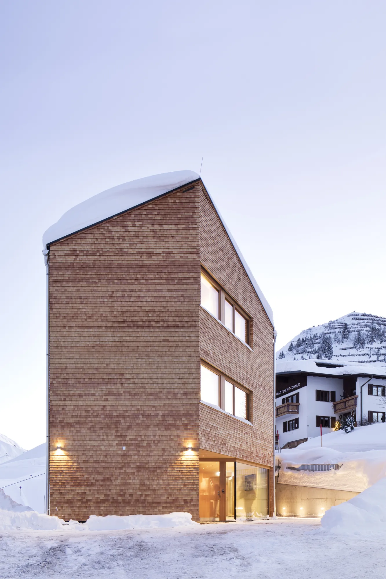 Modern wooden exterior of Rafter Warth in Warth, Austria, with snowy mountain surroundings visible