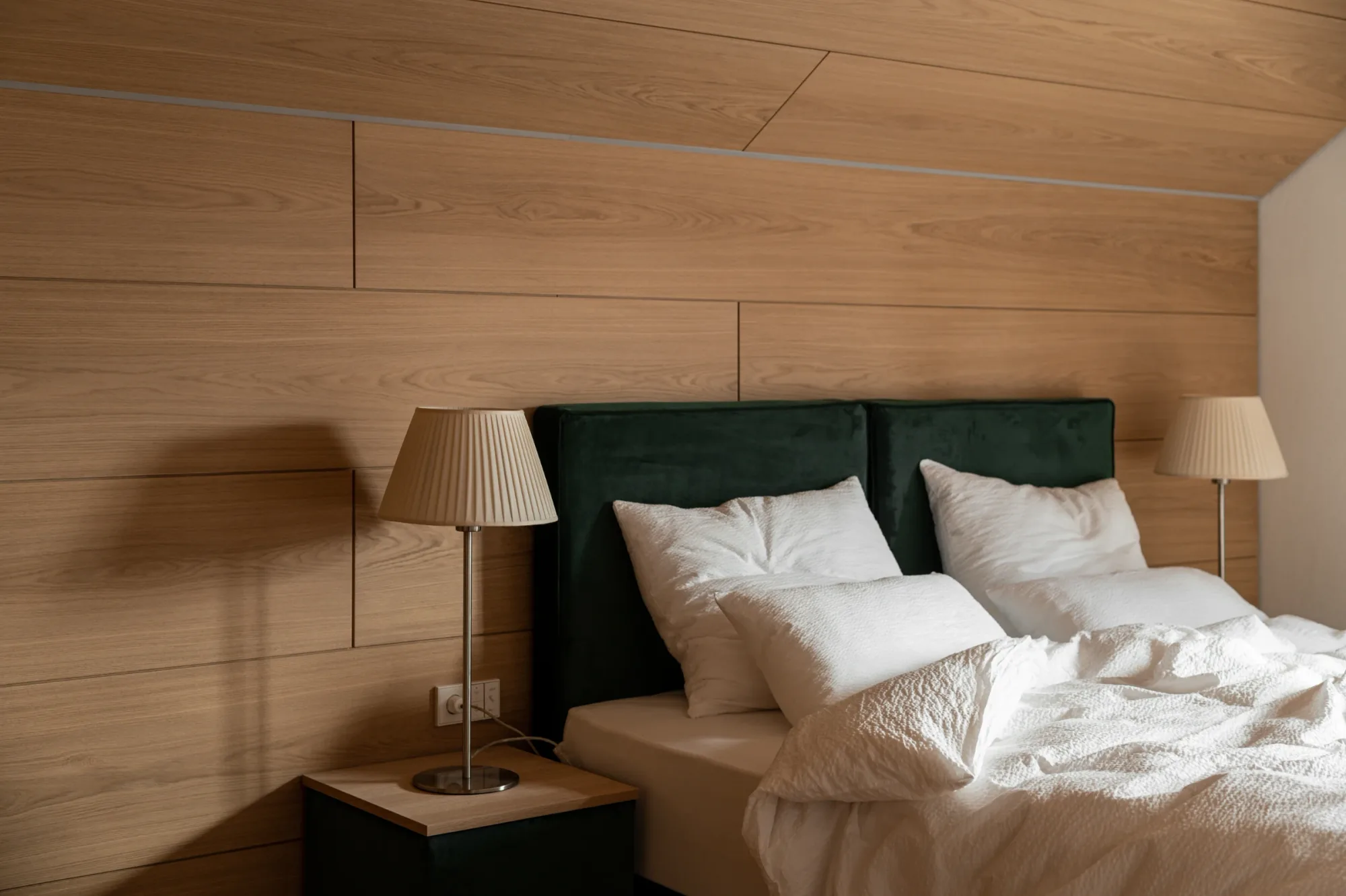 Bedroom with dark green upholstered headboard and bedside lamps at Rafter Bolzano Oberinn in Oberinn, Italy